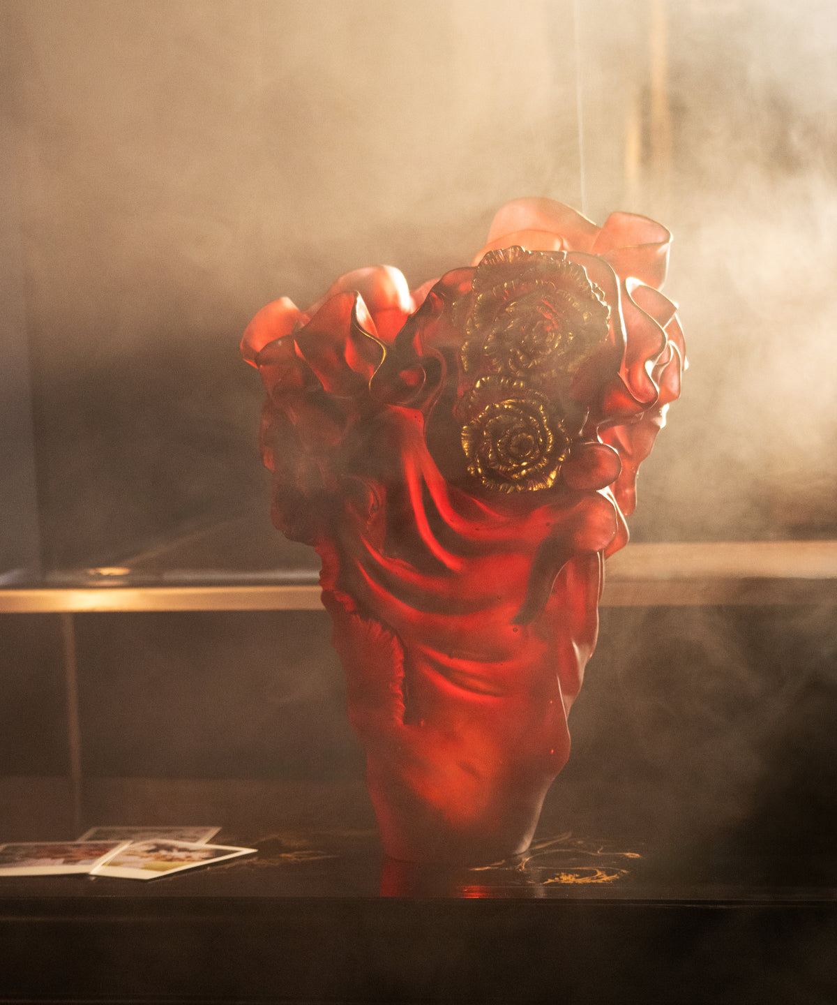 Vase Rose Royale grand modèle Daum rouge et or, décor élégant avec motifs floraux, sur fond blanc.