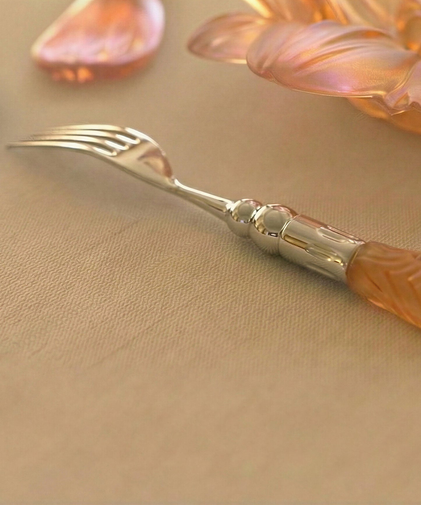 Deux fourchettes de table en or d'abeille de la marque Daum Intérieur, posées sur une nappe élégante.
