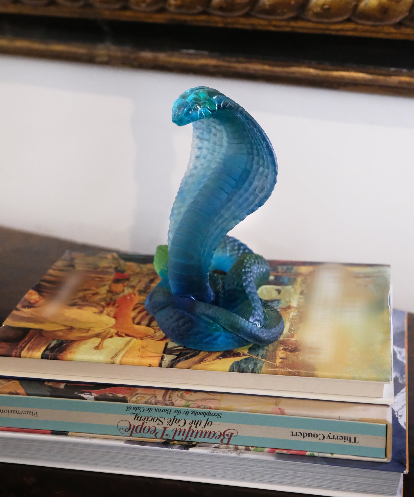 Naja en verre bleu de Daum, sculpture artistique élégante avec détails fins sur fond clair.