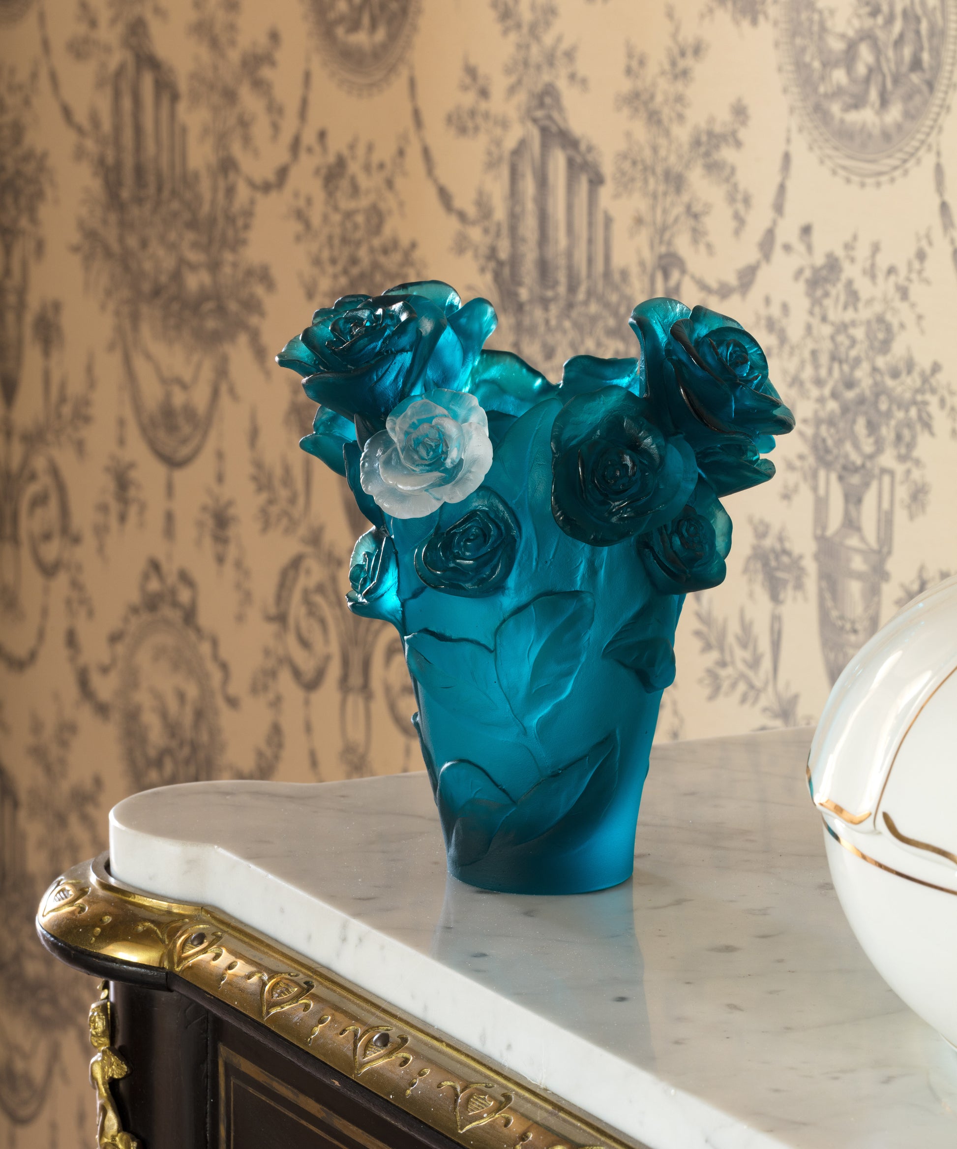 Vase Rose Passion petit modèle en verre bleu Daum avec une fleur blanche élégante.
